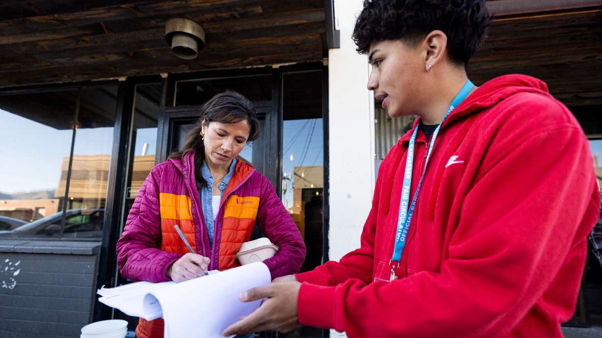Jennifer Lehnhof signs the HB267 referendum petition with Arian Pedraza of Landslide Political at Publik Coffee Roasters in Salt Lake City on March 26. A new Deseret News poll showed how Utahns would vote in the referendum.