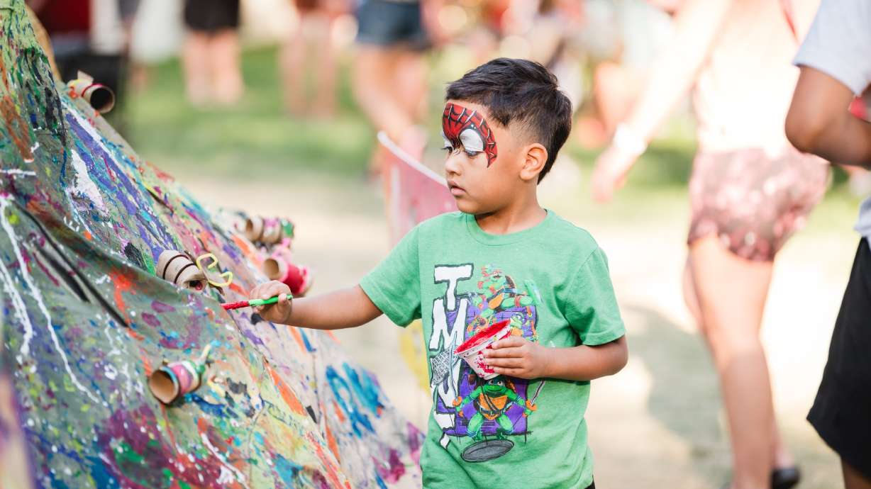 A child contributes to a public art piece at the Utah Arts Festival. Starting Thursday, downtown Salt Lake City will be filled with art of all mediums as part of the 49th annual festival.