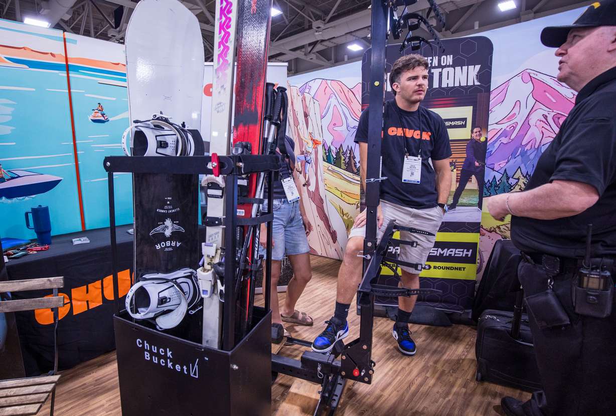 David Nelson, CEO of Chuck, center, speaks with another person while showcasing his product at the Utah Outdoor Business Incubator booth set up for Outdoor Retailer at the Salt Palace Convention Center on Wednesday.