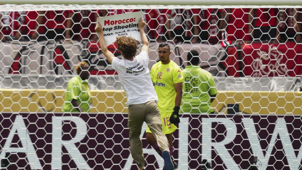 A protester runs on the pitch during the Club World Cup group G soccer match between Manchester City and Wydad AC in Philadelphia, Wednesday, June 18, 2025.