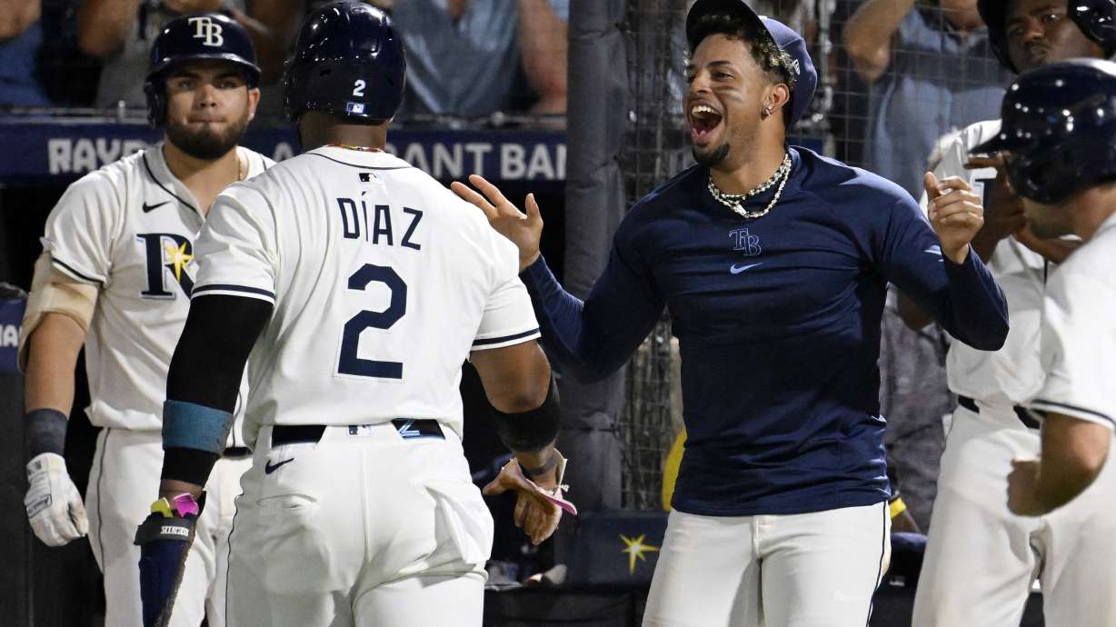 Tampa Bay Rays' Yandy Díaz (2) and Christopher Morel, right, celebrate after Diaz scored on a single by Junior Caminero, not pictured, during the seventh inning of a baseball game against the Baltimore Orioles, Wednesday, June 18, 2025, in Tampa, Fla.