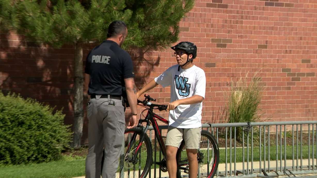 Officer Austin Larsen, a West Jordan High School resource officer, talks with student Aiden Hulet in West Jordan. Larsen donated a bike to Aiden after Aiden's old bike was damaged.