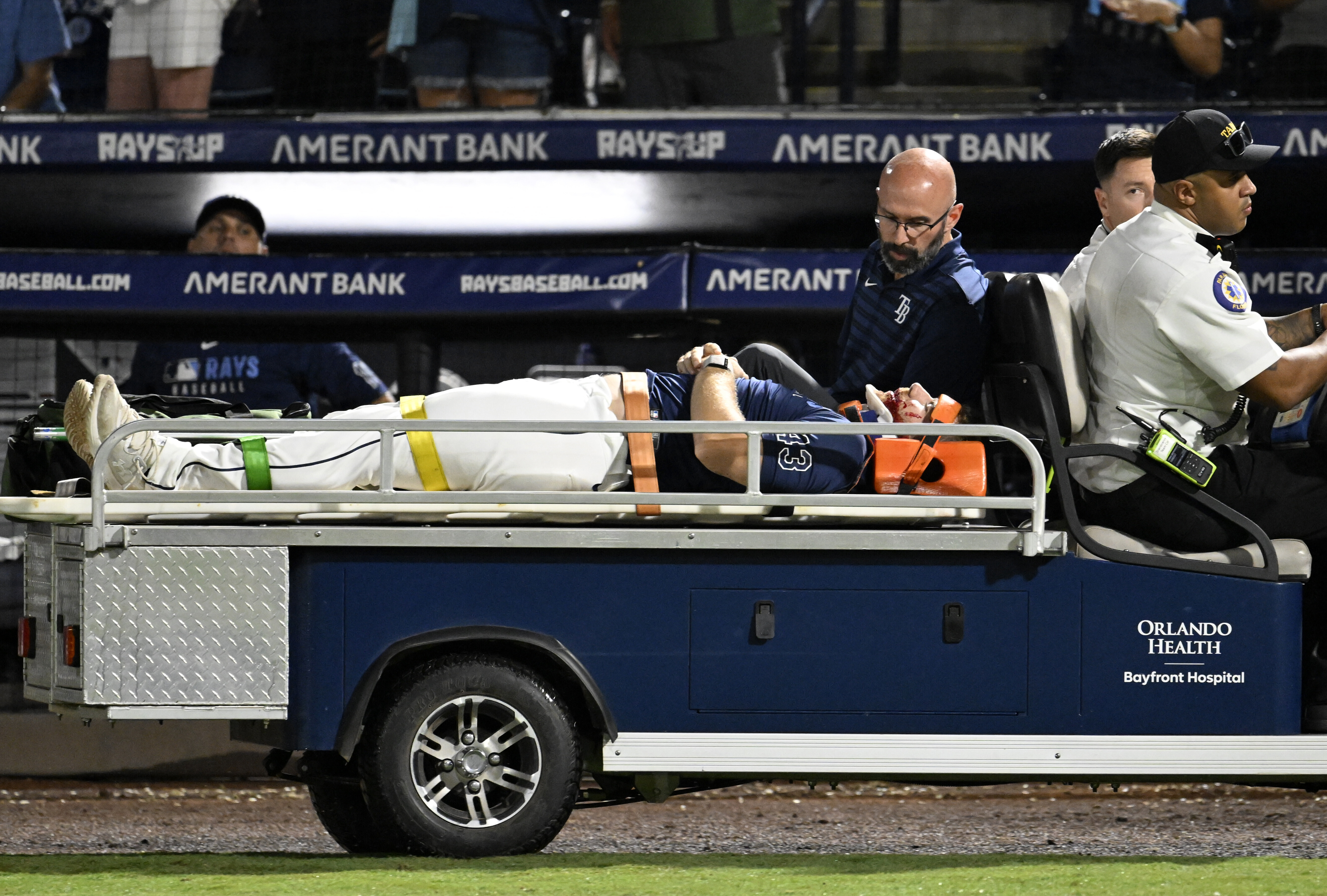 Tampa Bay Rays' Hunter Bigge is taken off the field after being hit by a foul ball while in the dugout during the seventh inning of a baseball game against the Baltimore Orioles, Thursday, June 19, 2025, in Tampa, Fla.