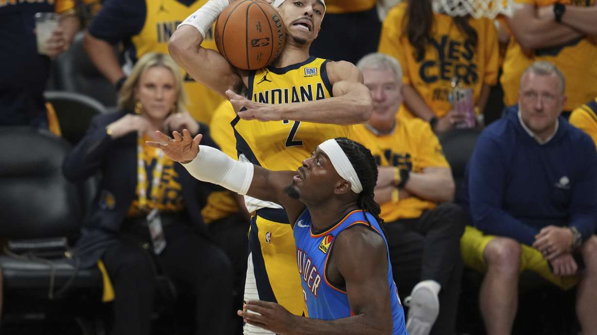 Indiana Pacers guard Andrew Nembhard (2) rebounds over Oklahoma City Thunder guard Luguentz Dort during the second half of Game 6 of the NBA Finals basketball series, Thursday, June 19, 2025, in Indianapolis.