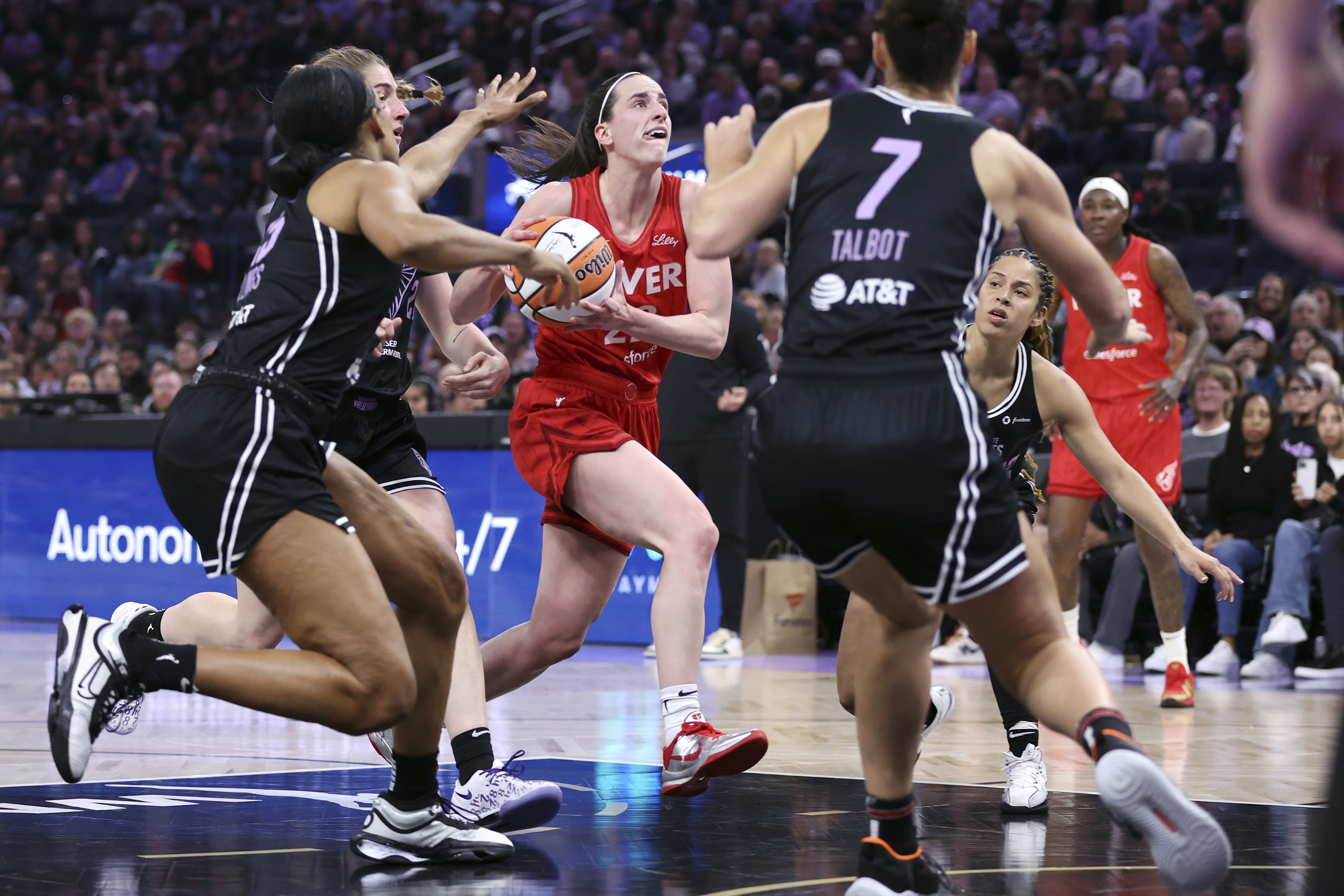 Indiana Fever's Caitlin Clark, center, drives to the basket between Golden State Valkyries players in the second quarter of a WNBA basketball game in San Francisco, Thursday, June 19, 2025.