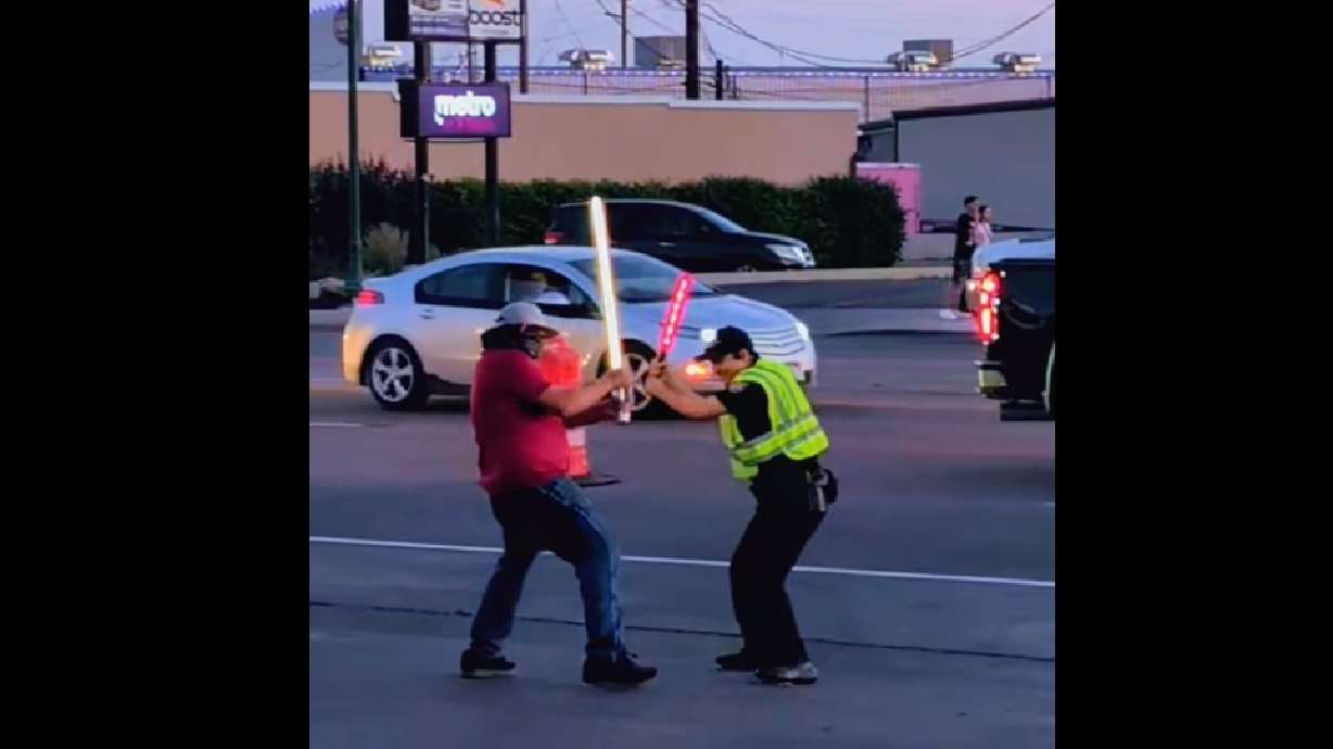 An Orem officer with a brightly lit traffic control baton, right, engaged in a mock battle with an adversary with a lightsaber. Video of the faux clash on the Orem Police Department Facebook page on Thursday delighted many.