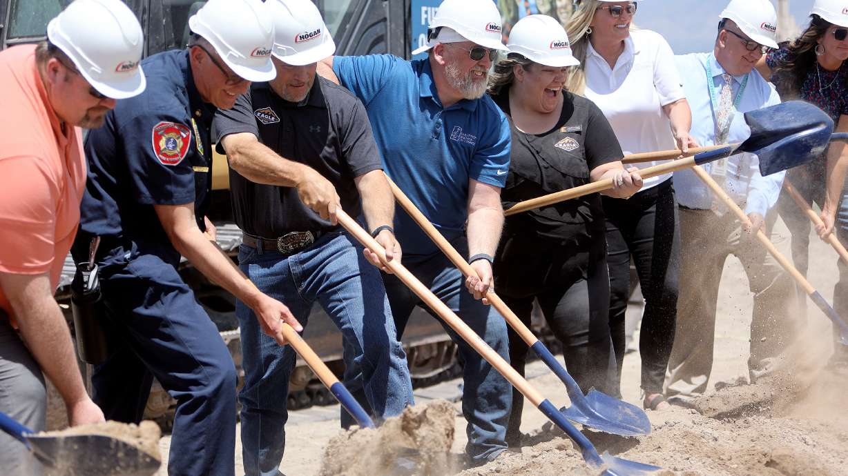 People participate in the turning of the dirt at a groundbreaking ceremony for a new high school in Saratoga Springs on Friday.