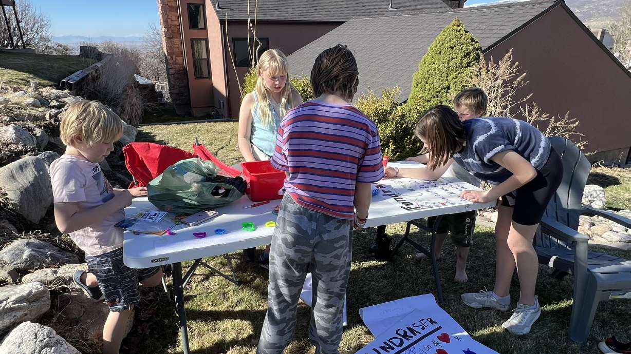 Children get a stand ready to raise funds for Paisley Knapp, a 2-year-old girl fighting neuroblastoma. The friends have spent hours outside raising money for her.