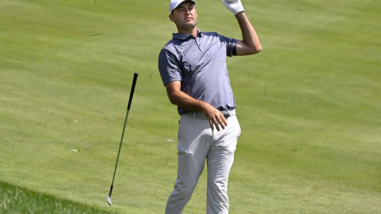 Scottie Scheffler drops his club after hitting his second shot from the rough on the first hole during the second round of the Travelers Championship golf tournament at TPC River Highlands, Friday, June 20, 2025, in Cromwell, Conn.
