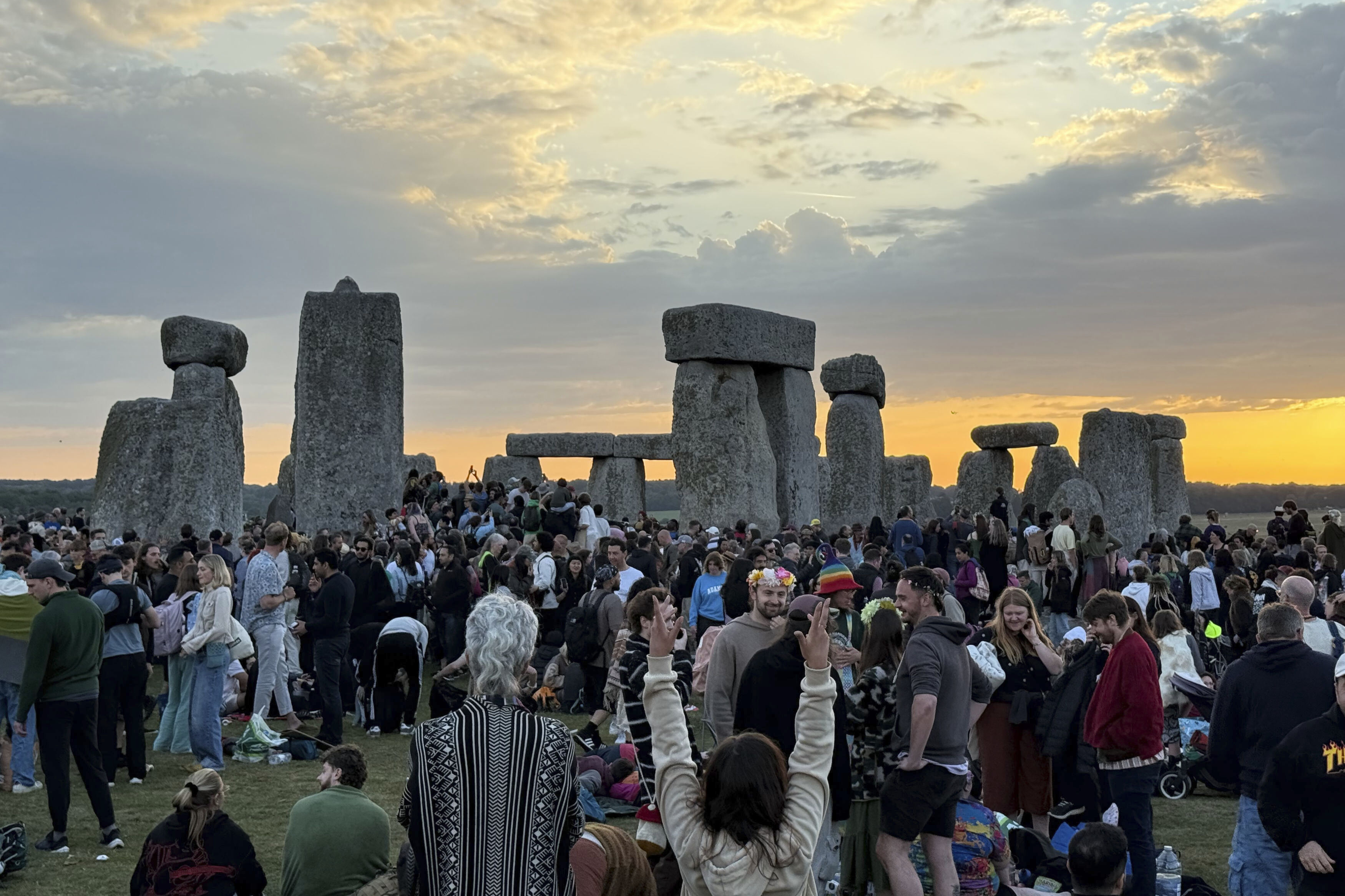 People gather at Stonehenge, England, during sunrise on the summer solstice, the longest day of the year, Saturday.
