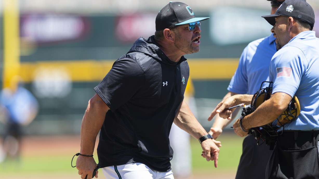 Coastal Carolina head coach Kevin Schnall, left, screams at the umpires after being ejected in the first inning against LSU in Game 2 of the NCAA College World Series baseball finals in Omaha, Neb., Sunday, June 22, 2025.