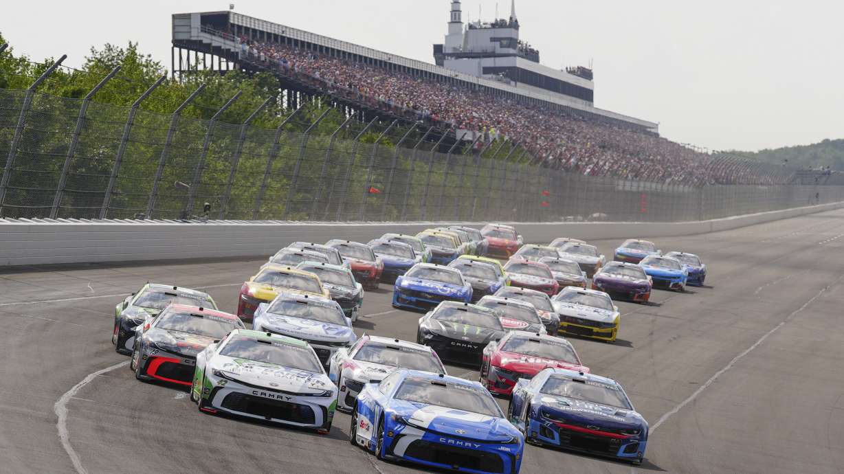Denny Hamlin (11) leads the field into Turn 1 to start the NASCAR Cup Series auto race at Pocono Raceway, Sunday, June 22, 2025, in Long Pond, Pa.