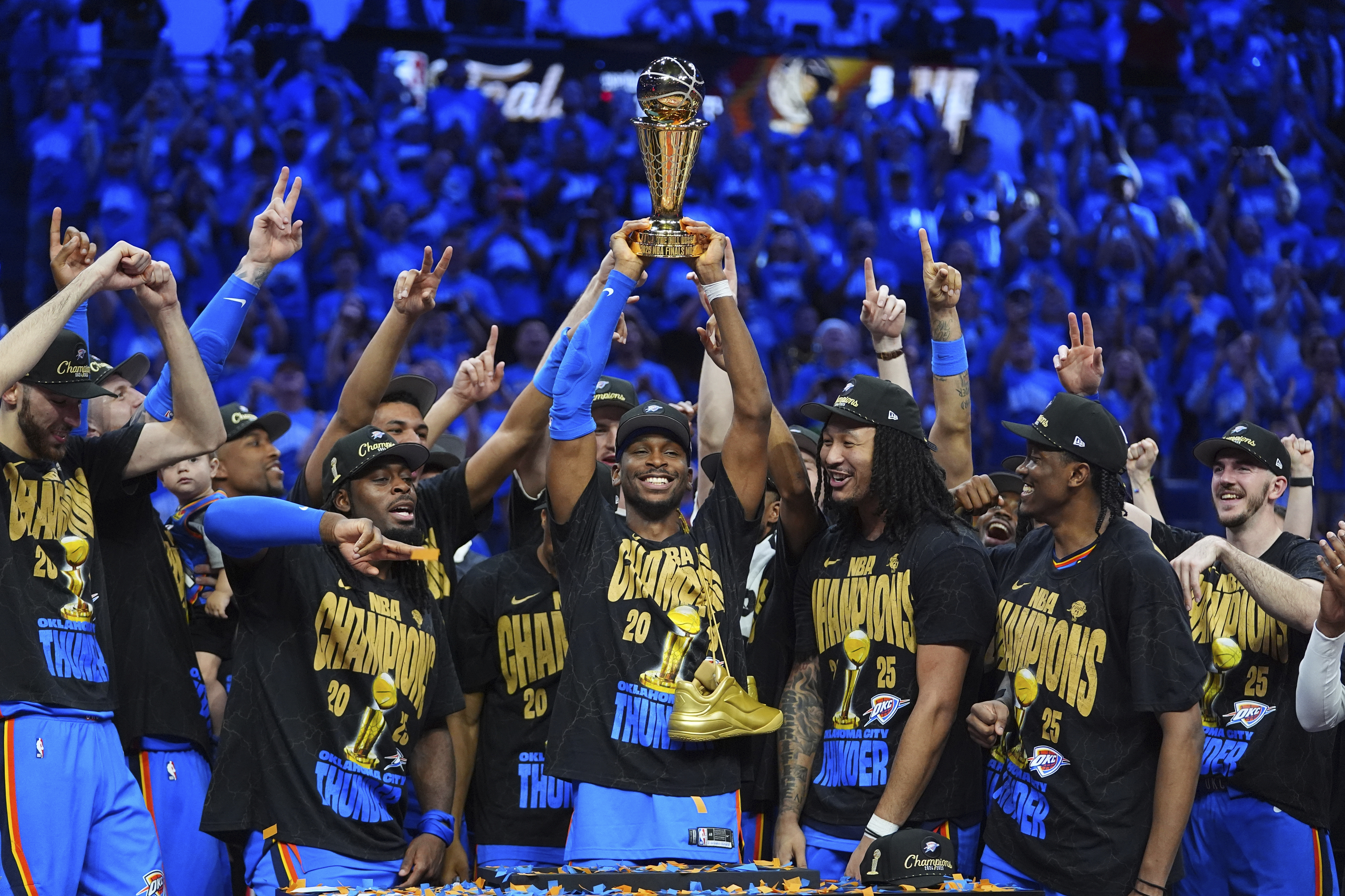 Oklahoma City Thunder guard Shai Gilgeous-Alexander, center, holds up the MVP trophy as he celebrates with his team after they won the NBA basketball championship with a Game 7 victory against the Indiana Pacers Sunday, June 22, 2025, in Oklahoma City.