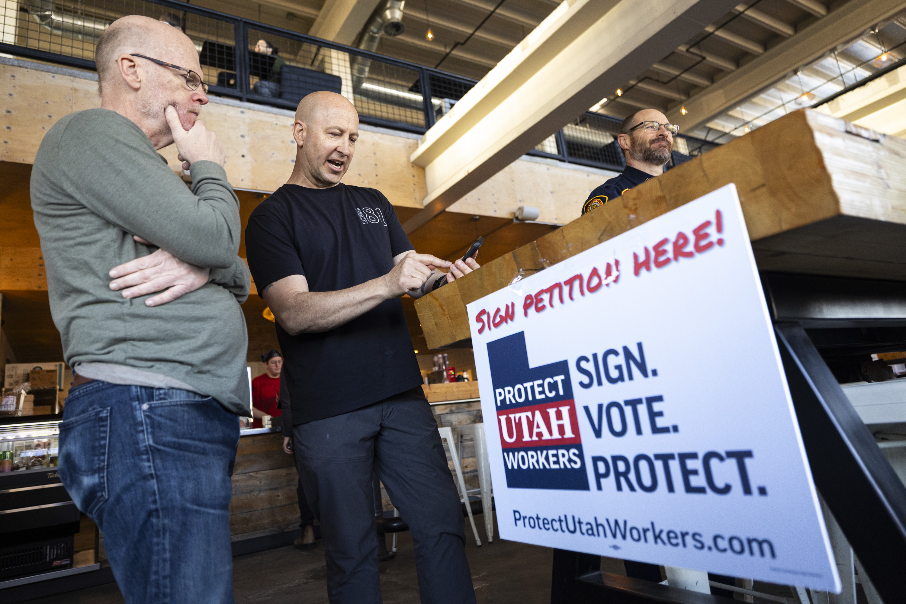 Salt Lake City firefighter John Stevens talks with Mark Simons during a signature-gathering event for a referendum to repeal HB267 in Salt Lake City on March 26. Voters will weigh in on the law during the November 2026 general election.