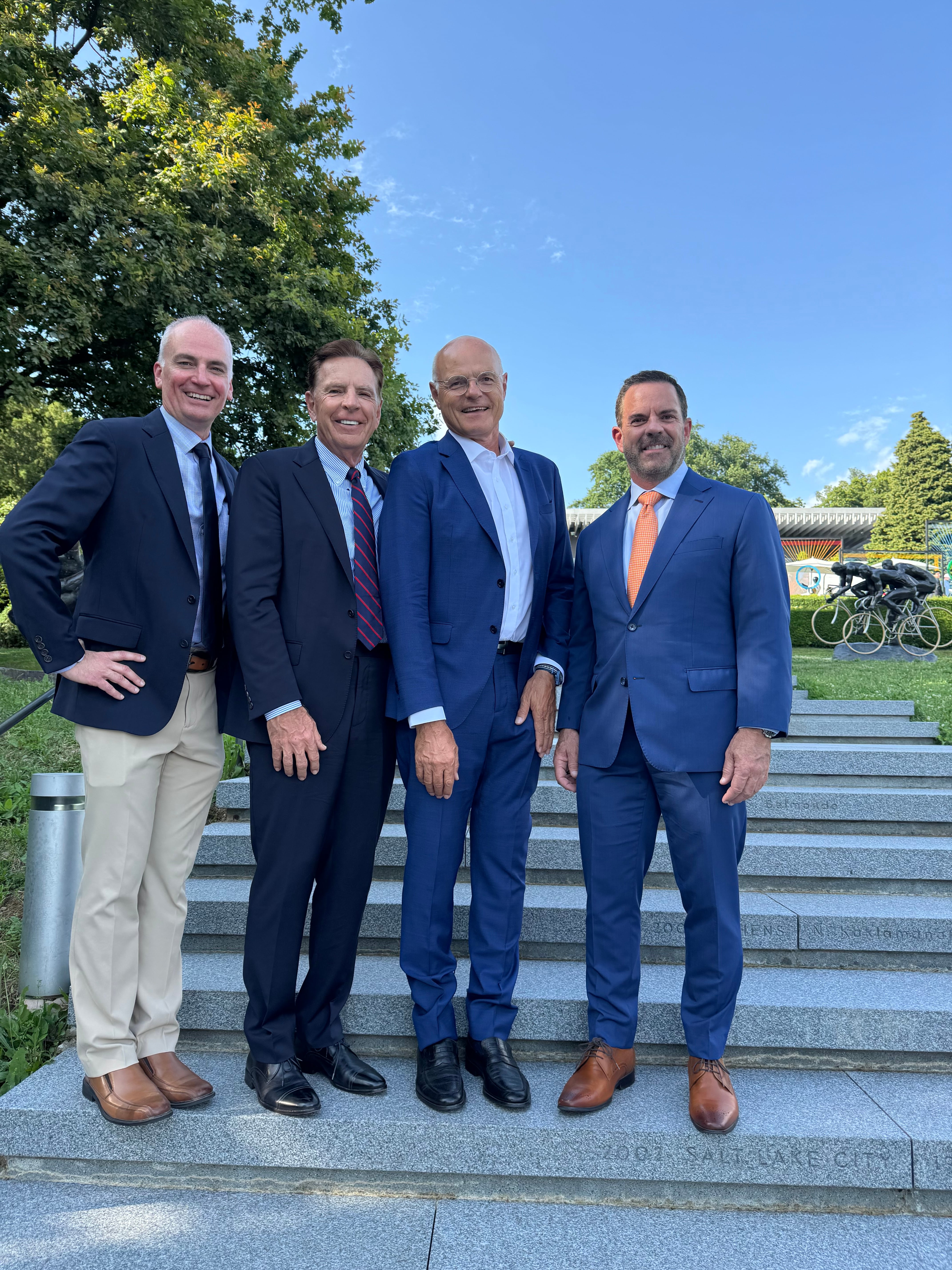 From left, Darren Hughes, vice president of the Utah Organizing Committee for the 2034 Olympic and Paralympic Winter Games, Fraser Bullock, president and executive chair of the Utah Organizing Committee for the 2034 Olympic and Paralympic Winter Games, Karl Stoss, an International Olympic Committee member from Austria who was chair of the IOC Future Host Commission that evaluated Utah’s Olympic bid, and Brad Wilson, CEO of the Utah Organizing Committee for the 2034 Olympic and Paralympic Winter Games, on the steps of the Olympic Museum in Lausanne, Switzerland. An inscription for the 2001 Games in Salt Lake City can be seen near Wilson's feet.
