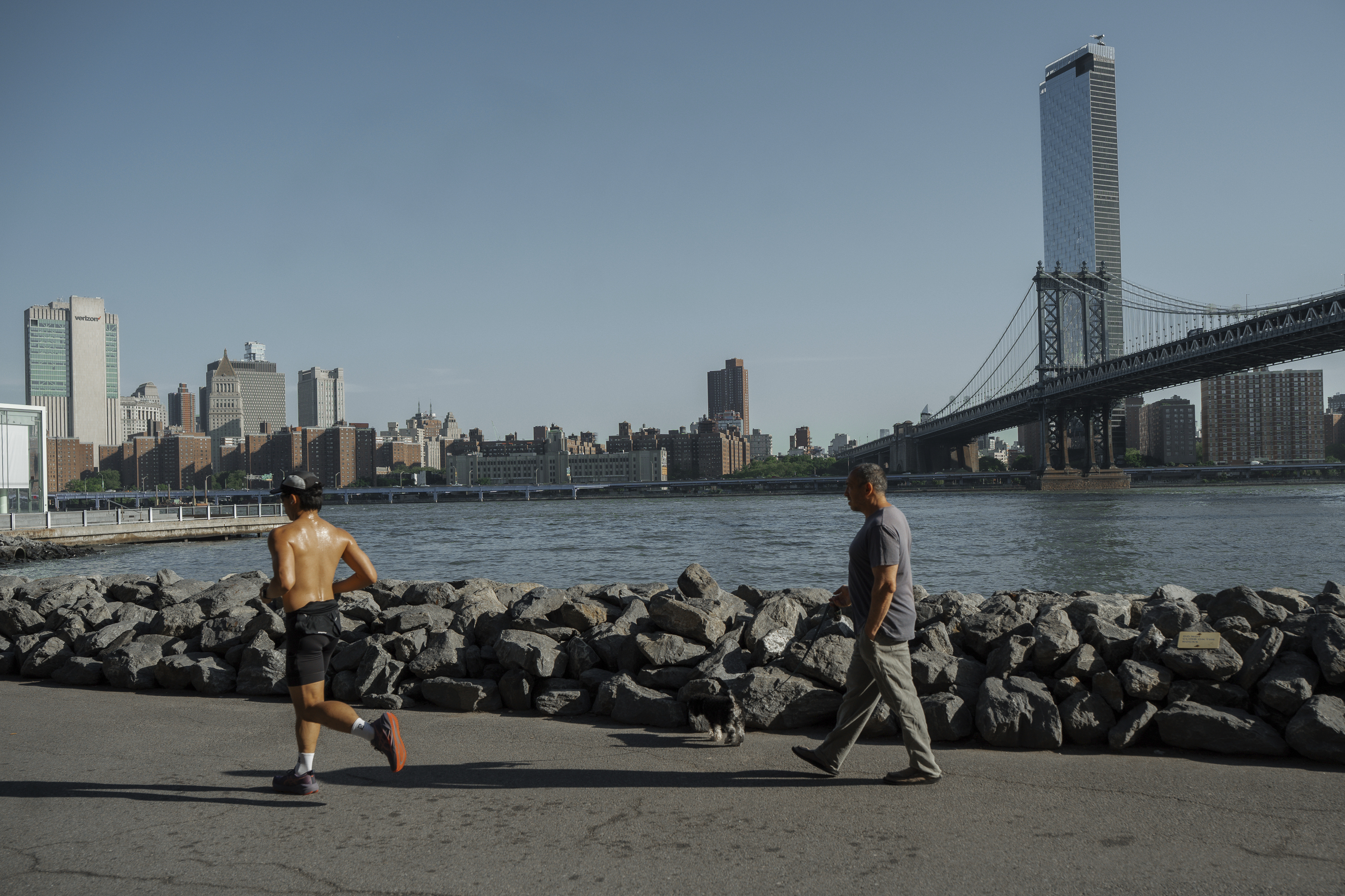 People exercise on the Brooklyn waterfront during a heatwave on Tuesday, June 24, 2025, in New York.