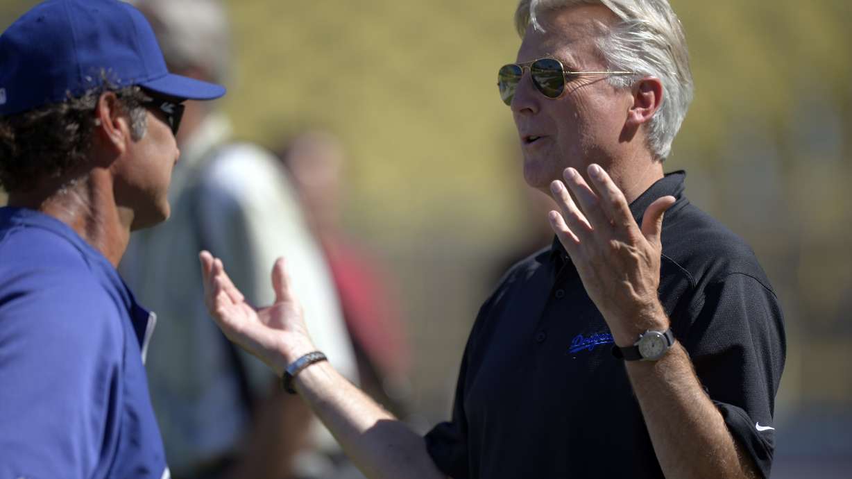 FILE - Los Angeles Dodgers co-owner Mark Walter, right, talks with manager Don Mattingly prior to their baseball game against the San Diego Padres, Sept. 3, 2012, in Los Angeles.