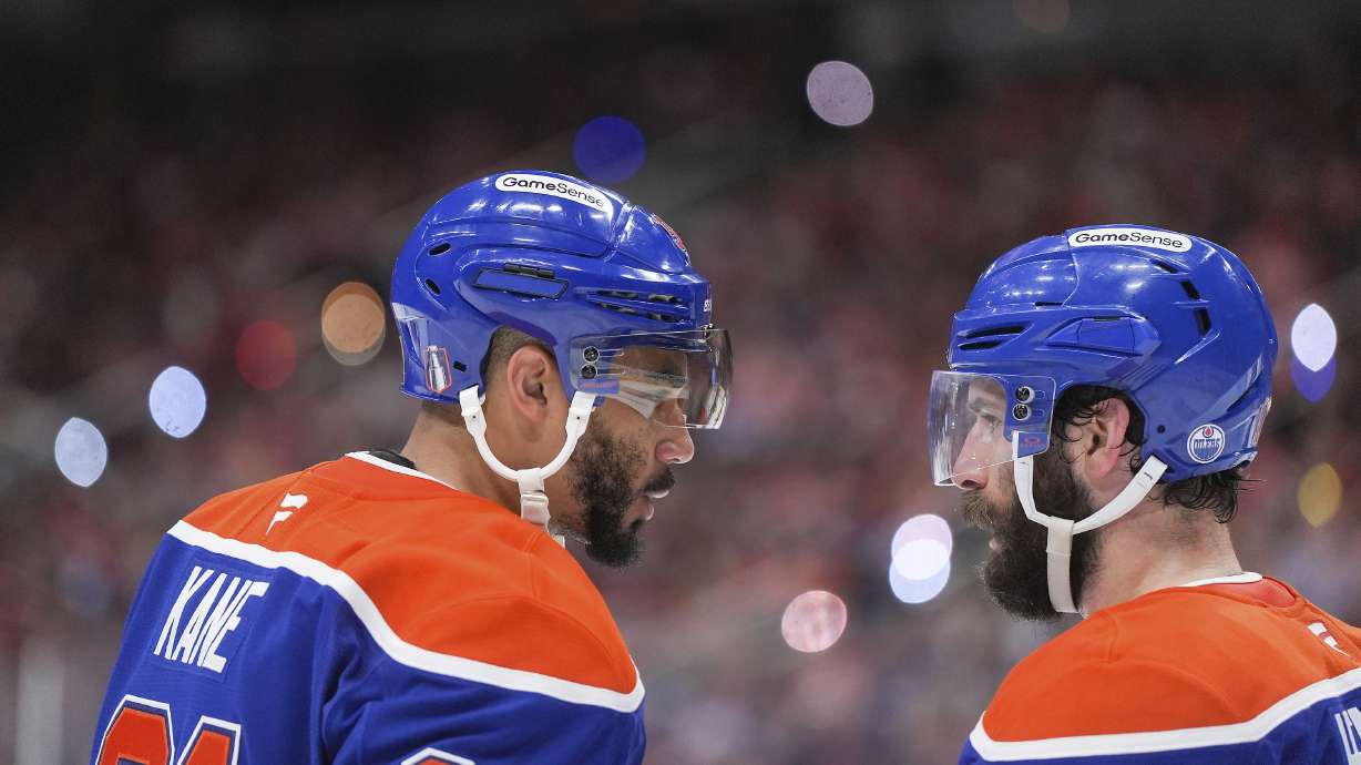Edmonton Oilers' Evander Kane, left, talks to Adam Henrique before a faceoff during third period of Game 5 of the NHL Stanley Cup final against the Florida Panthers, in Edmonton, Alberta, Saturday, June 14, 2025.