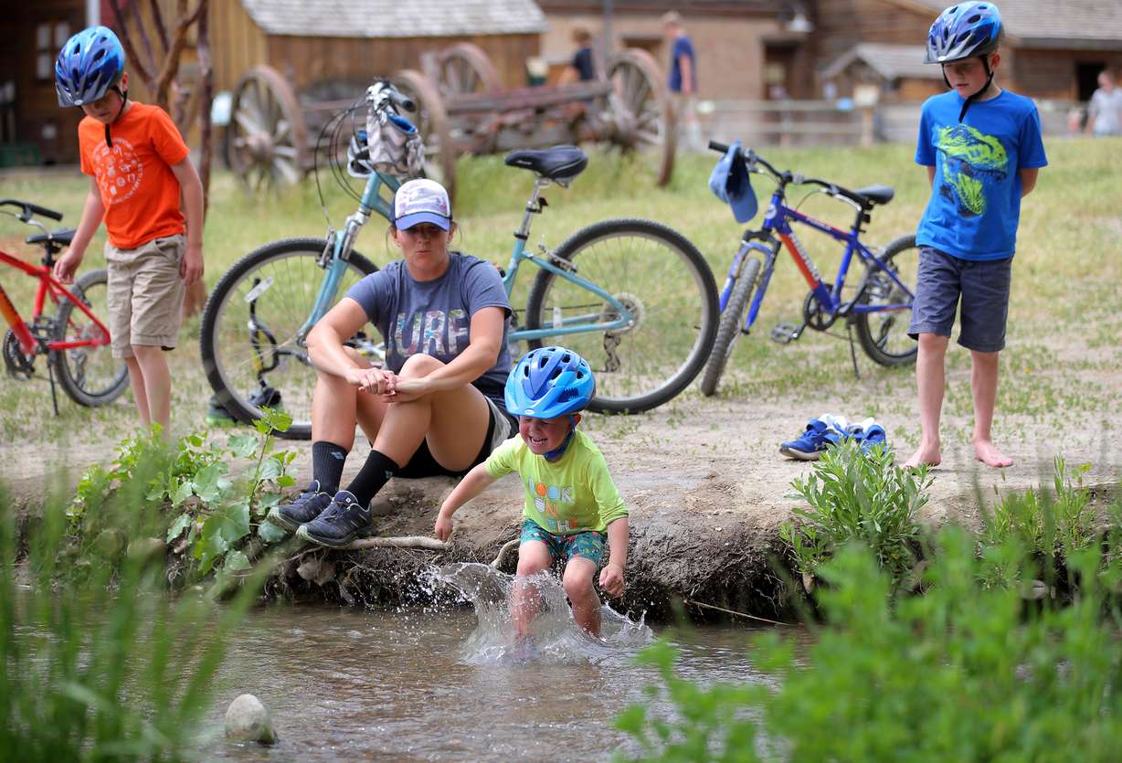 Katie Campbell watches Carson jump into the water as her other sons Weston and Hayden stand nearby at Wheeler Historic Farm in Murray on May 19, 2020.