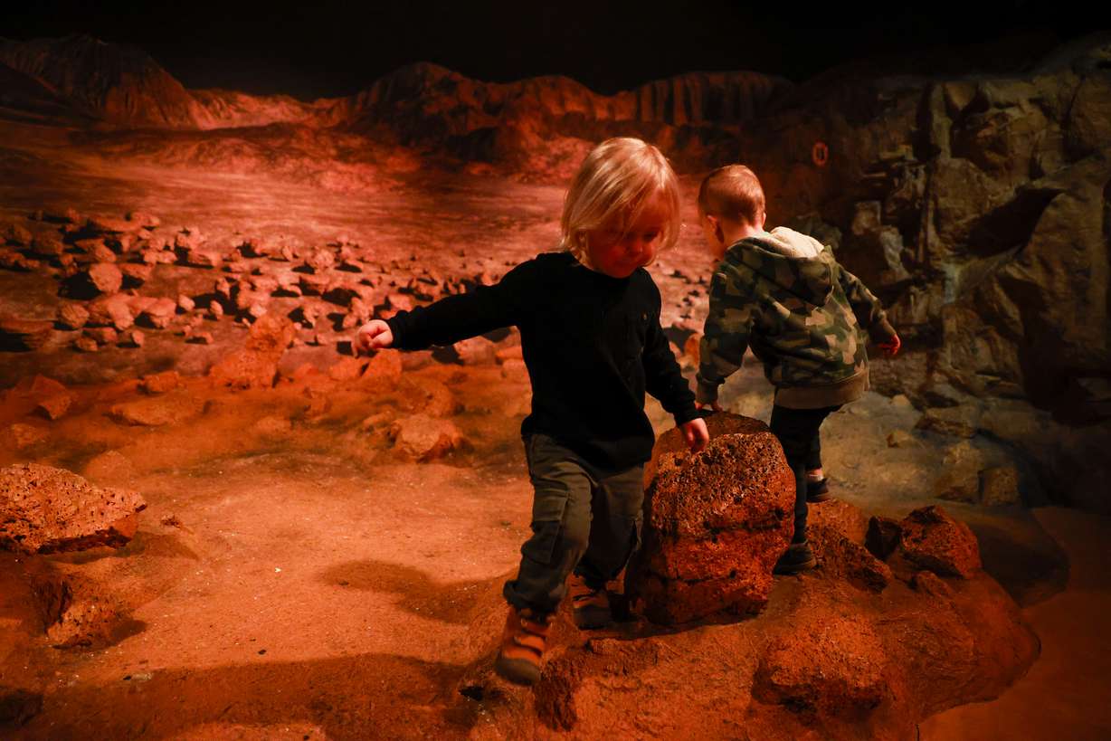 Torin Stott, 2, left, plays with his cousin Karson Stott, 2, in an installation at the Clark Planetarium during an event celebrating the 50th anniversary of Apollo 17 in Salt Lake City on Dec. 10, 2022.