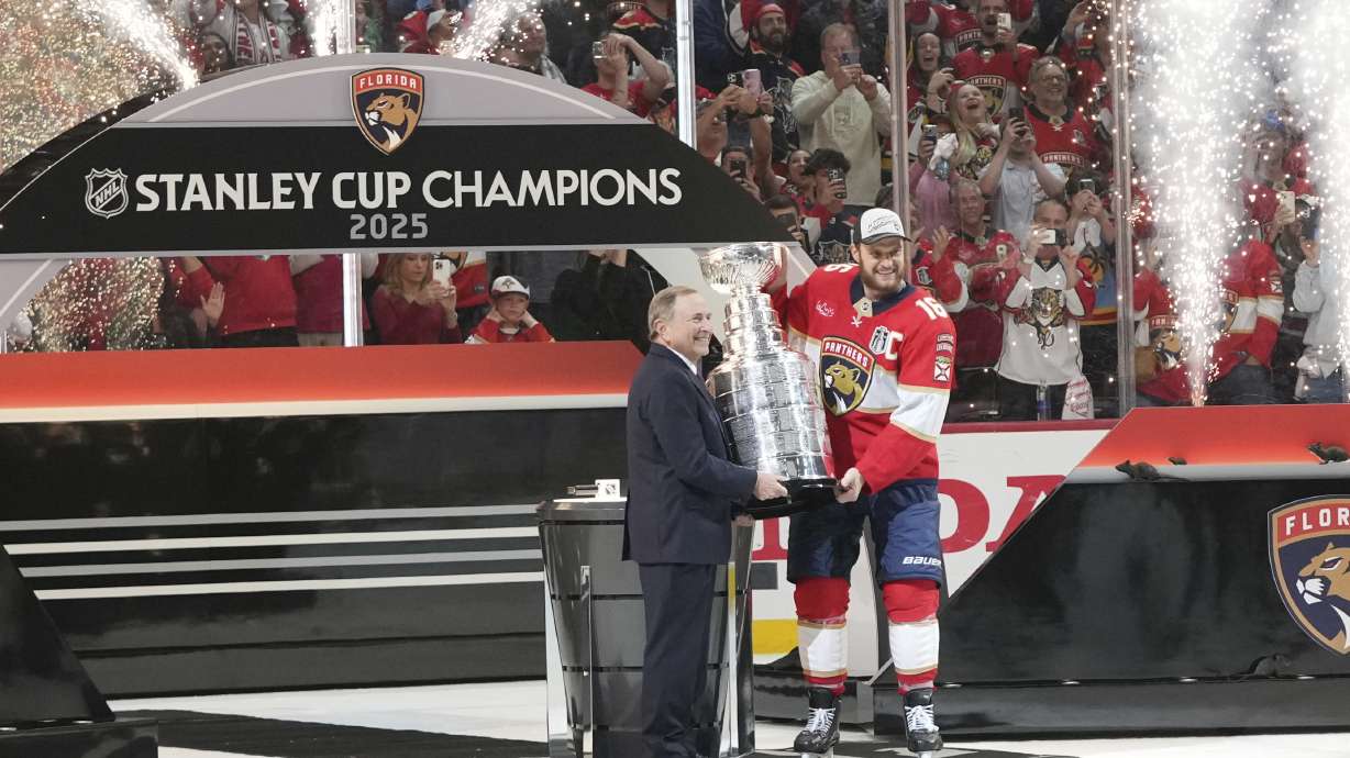 NHL commissioner Gary Bettman, left, hands the Stanley Cup to Florida Panthers captain Aleksander Barkov (16) after defeating the Edmonton Oilers in Game 6 of the NHL hockey Stanley Cup Final Tuesday, June 17, 2025, in Sunrise, Fla.