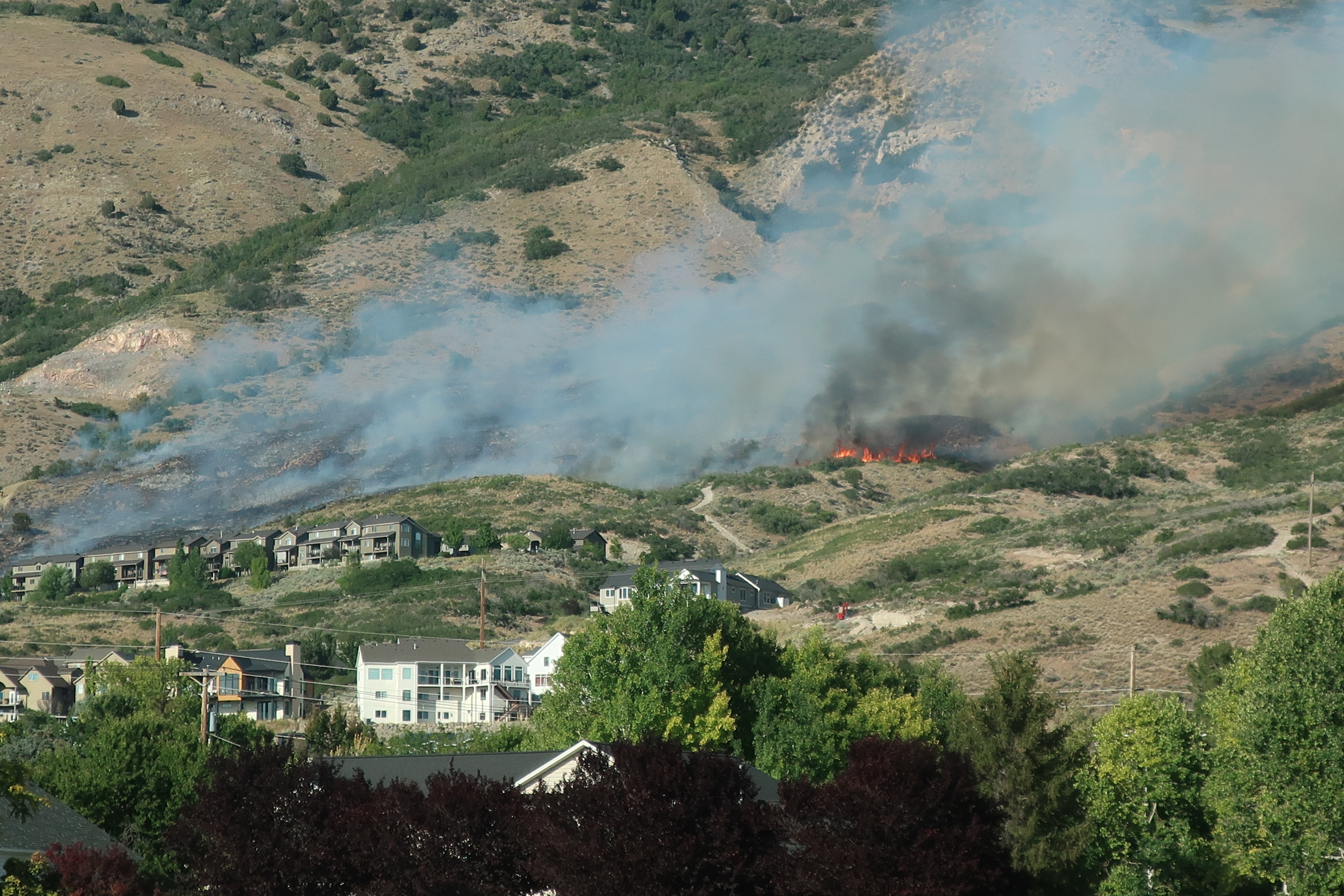 A new wildfire burning Wednesday evening on the hillside near Cedar Hills in Utah County is threatening structures, fire officials said.
