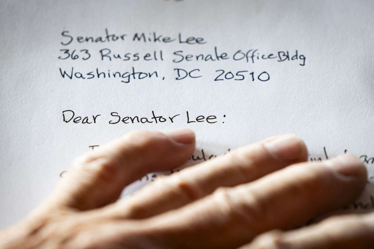 Evan Sugden, of Salt Lake City, writes a letter to Sen. Mike Lee, R-Utah, during a letter-writing event in Salt Lake City on Wednesday.