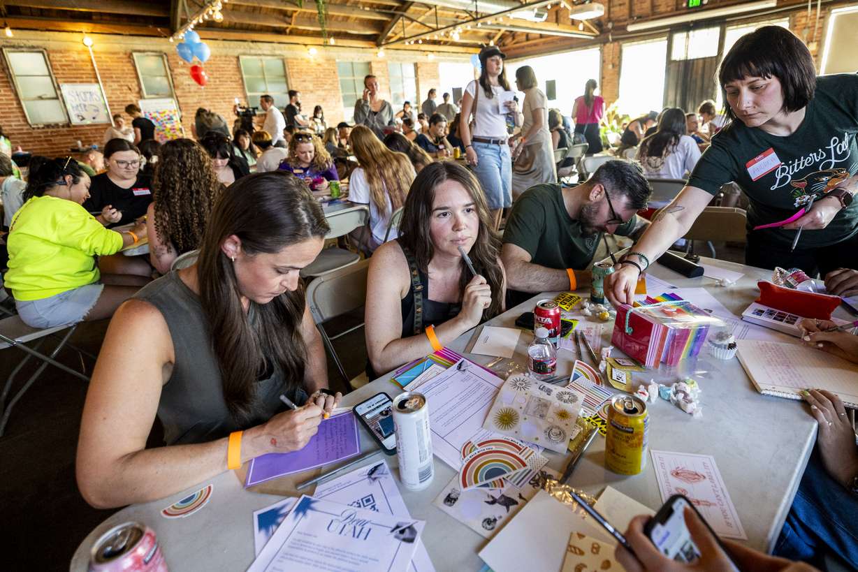 Sydney Shine, center, of Millcreek, listens to a friend as her husband, Matt Shine, right, and Jenn Delman, of Draper, write letters to Sen. Mike Lee, R-Utah, during a letter-writing event to hold Sen. Lee accountable, hosted by the Alliance for a Better Utah and Elevate Utah, held at Publik Coffee Roasters in Salt Lake City on Wednesday.