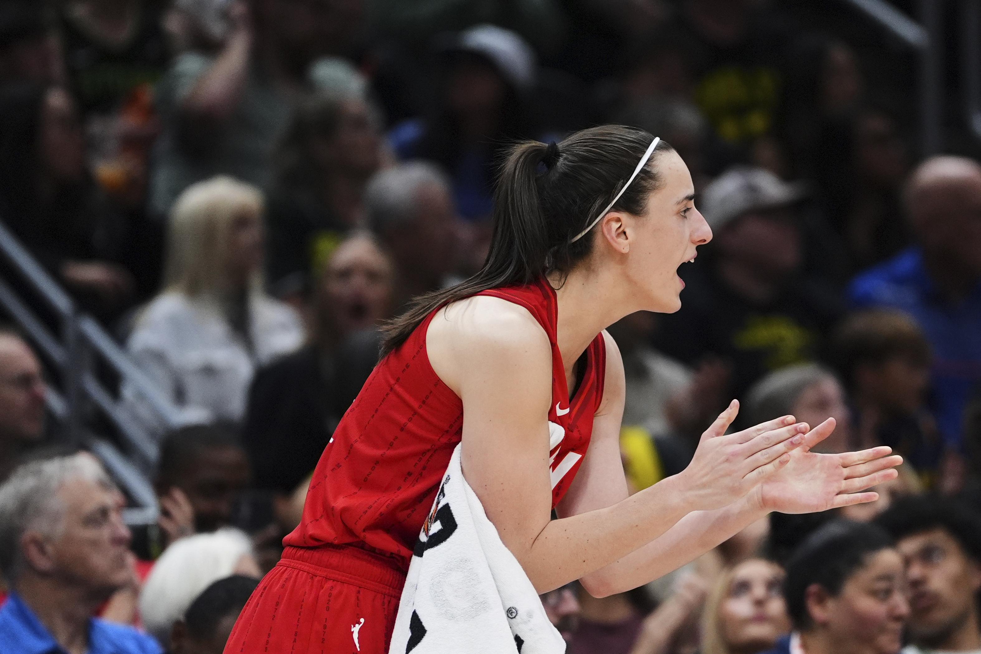 Indiana Fever guard Caitlin Clark claps from the bench during the second half of a WNBA basketball game against the Seattle Storm, Tuesday, June 24, 2025, in Seattle. 