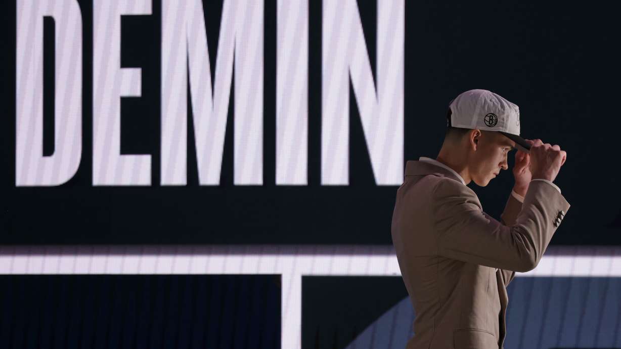 Egor Demin dons a cap as he walks on stage after being selected eighth by the Brooklyn Nets in the first round of the NBA basketball draft, Wednesday, June 25, 2025, in New York.