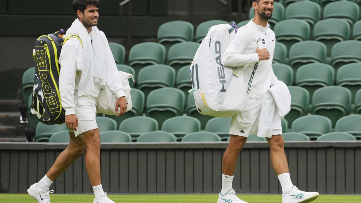Novak Djokovic of Serbia, right, and Carlos Alcaraz of Spain, left, arrive for a practice session on Centre Court at the All England Lawn Tennis and Croquet Club, ahead of the Wimbledon Championships in London, Thursday, June 26, 2025.