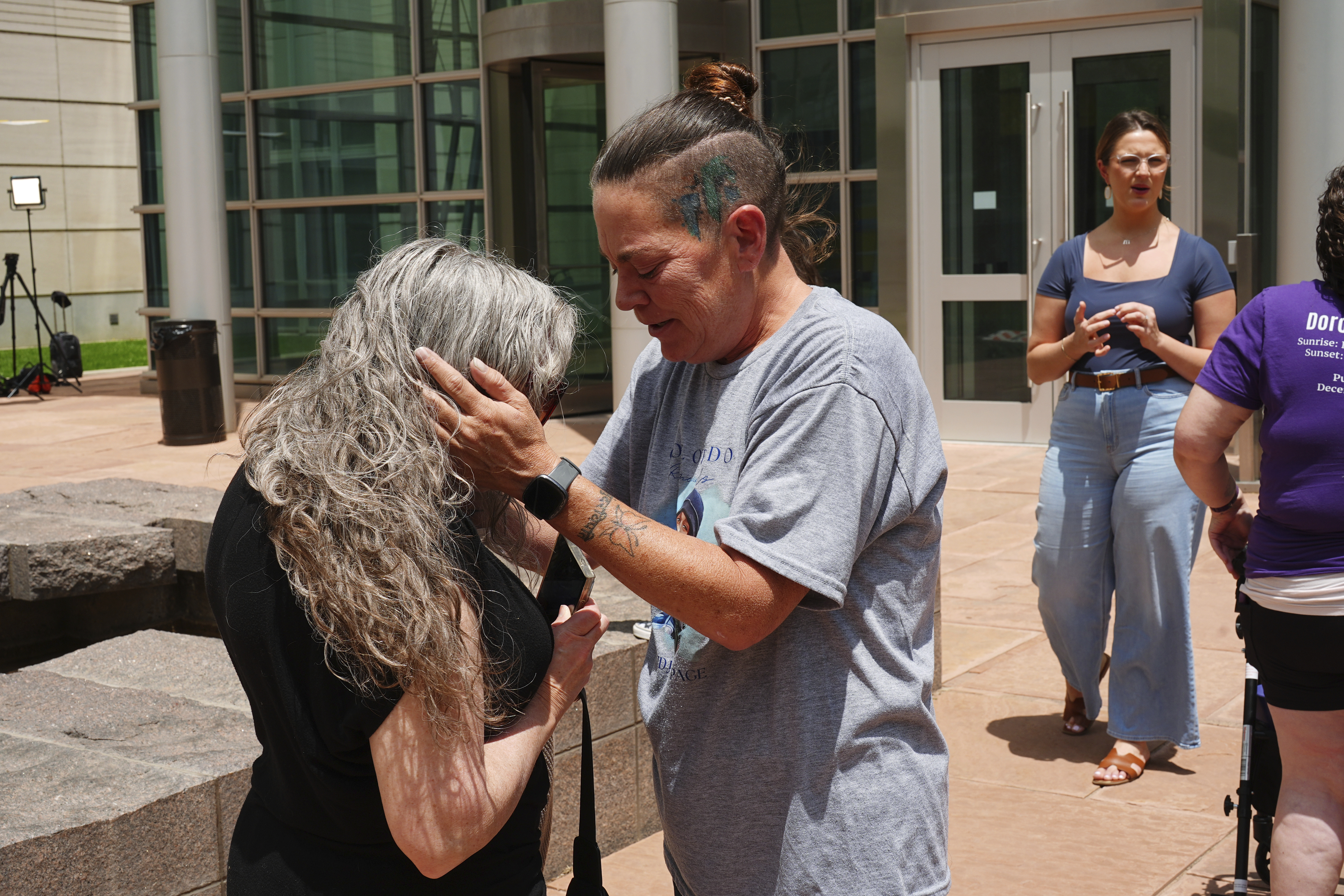 Crystina Page hugs Beth Mosley after Jon Hallford, the owner of Back to Nature Funeral Home, was sentenced to 20 years prison on federal fraud charges, Friday in Denver.