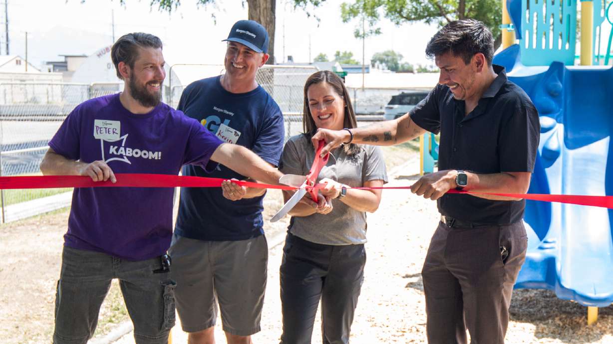 Salt Lake City Council Vice Chairman Alejandro Puy, on the farthest right, cuts a ribbon along representatives of Salt Lake City, Morgan Stanley and Kaboom to celebrate a new playground at Madsen Park in Salt Lake City on Friday.