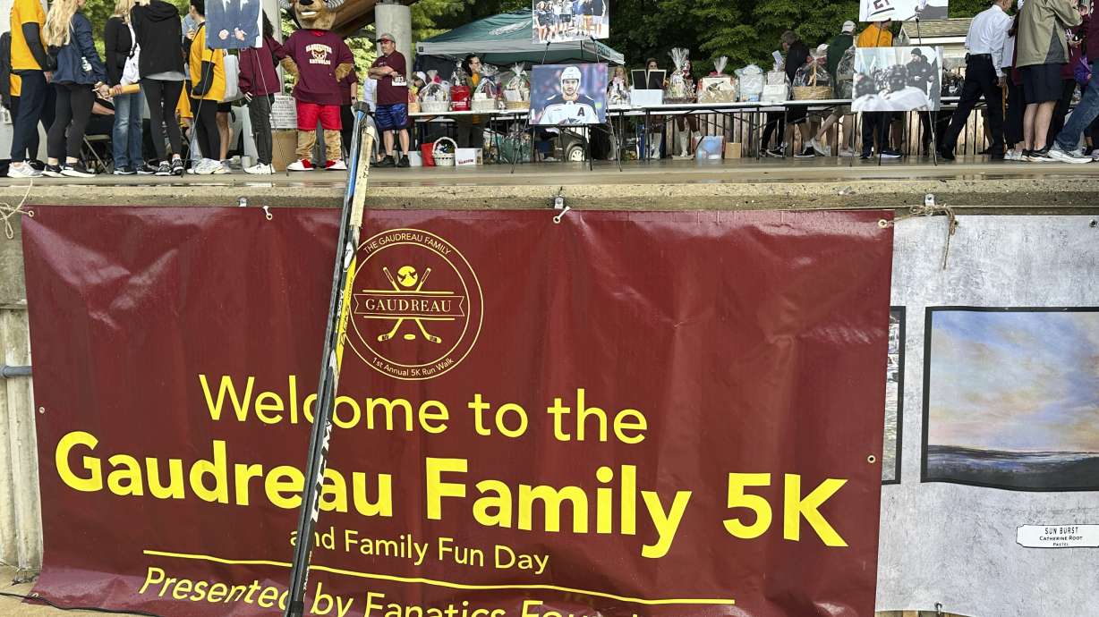 Hockey sticks from various vigils for hockey players Johnny and Matthew Gaudreau, who were fatally struck by a motorist while riding bicycles, rest against a sign at the inaugural Gaudreau Family 5K Walk, Run and Family Day, Saturday, May 31, 2025, in Sewell, N.J.