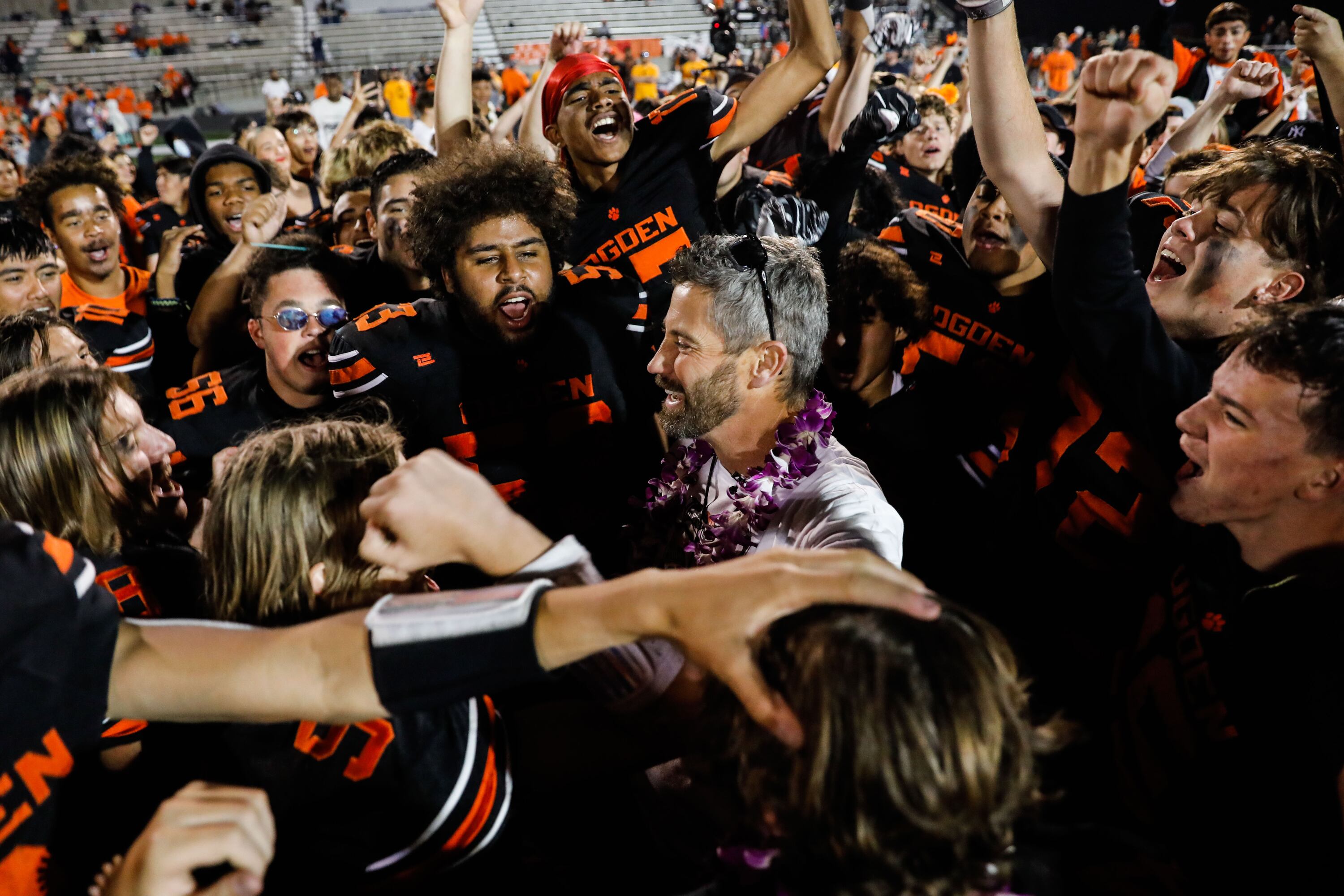 Ogden football coach Erik Thompson celebrates with his team during “Erik Thompson Night” on Sept. 3, 2021, at Ogden High School shortly after he was diagnosed with ALS. The Thompson family moved into their new home Friday.