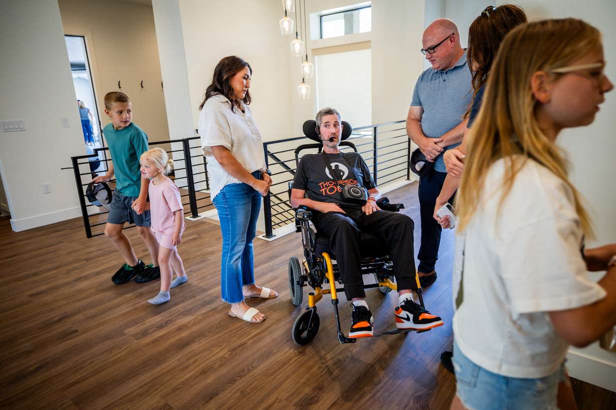 Brian Berrong speaks to Erik Thompson and his wife Skye after a ceremony to commemorate their new home in South Weber on Friday. Skye Thompson invited those who came to the ceremony to tour the family's new home.