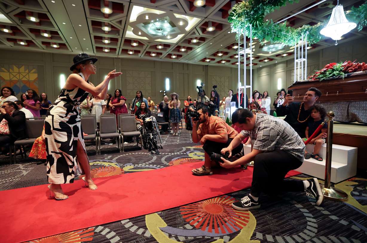 A guest blows a kiss to the casket of Afa Ah Loo while walking the catwalk with many others to celebrate the life of fashion designer Afa Ah Loo, who was shot and killed as an innocent bystander during a No Kings protest, at the Salt Palace Convention Center in Salt Lake City on Friday.