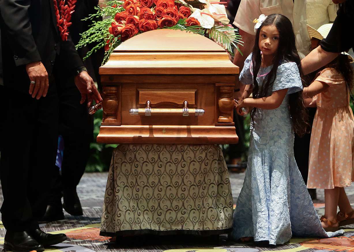 Vera Ah Loo walks with her father Afa Ah Loo’s casket at the end of his celebration of life at the Salt Palace Convention Center in Salt Lake City on Friday. Afa was shot and killed as an innocent bystander during a No Kings protest.