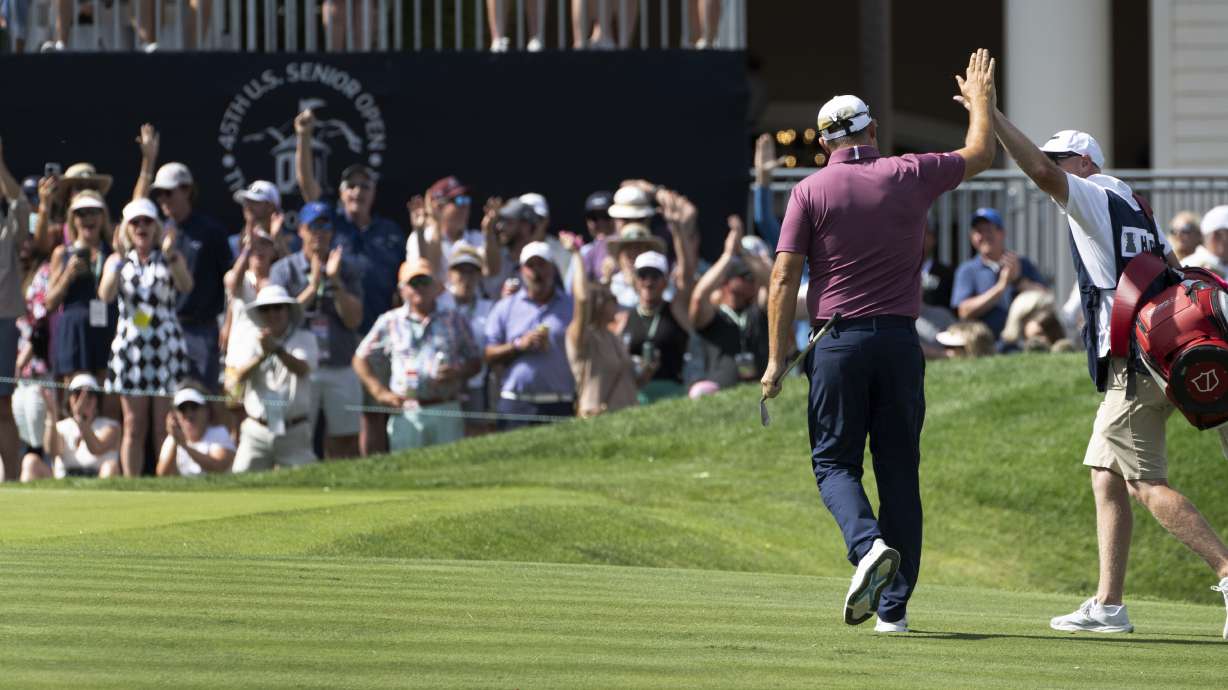 Padraig Harrington, left, high fives his caddie, Ronan Flood, after Harrington chipped in for a birdie on the 18th hole during the third round of the 45th U.S. Senior Open Championship Saturday, June 28, 2025, at the Broadmoor Golf Club in Colorado Springs, Colo.