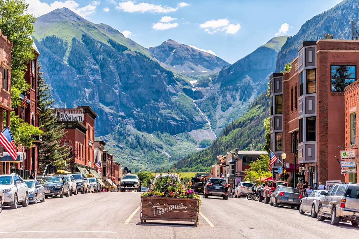 Telluride, Colorado on Aug. 14, 2019: Small town village in Colorado with sign for city and flowers by historic architecture on main street mountain view