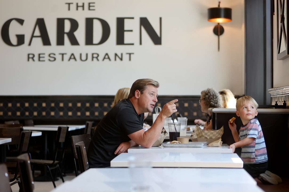 Jon Matthew Brown and Henry Brown look out the window of The Garden Restaurant while eating there on the first day it is reopened after a two-and-a-half-year renovation in Salt Lake City on Monday.