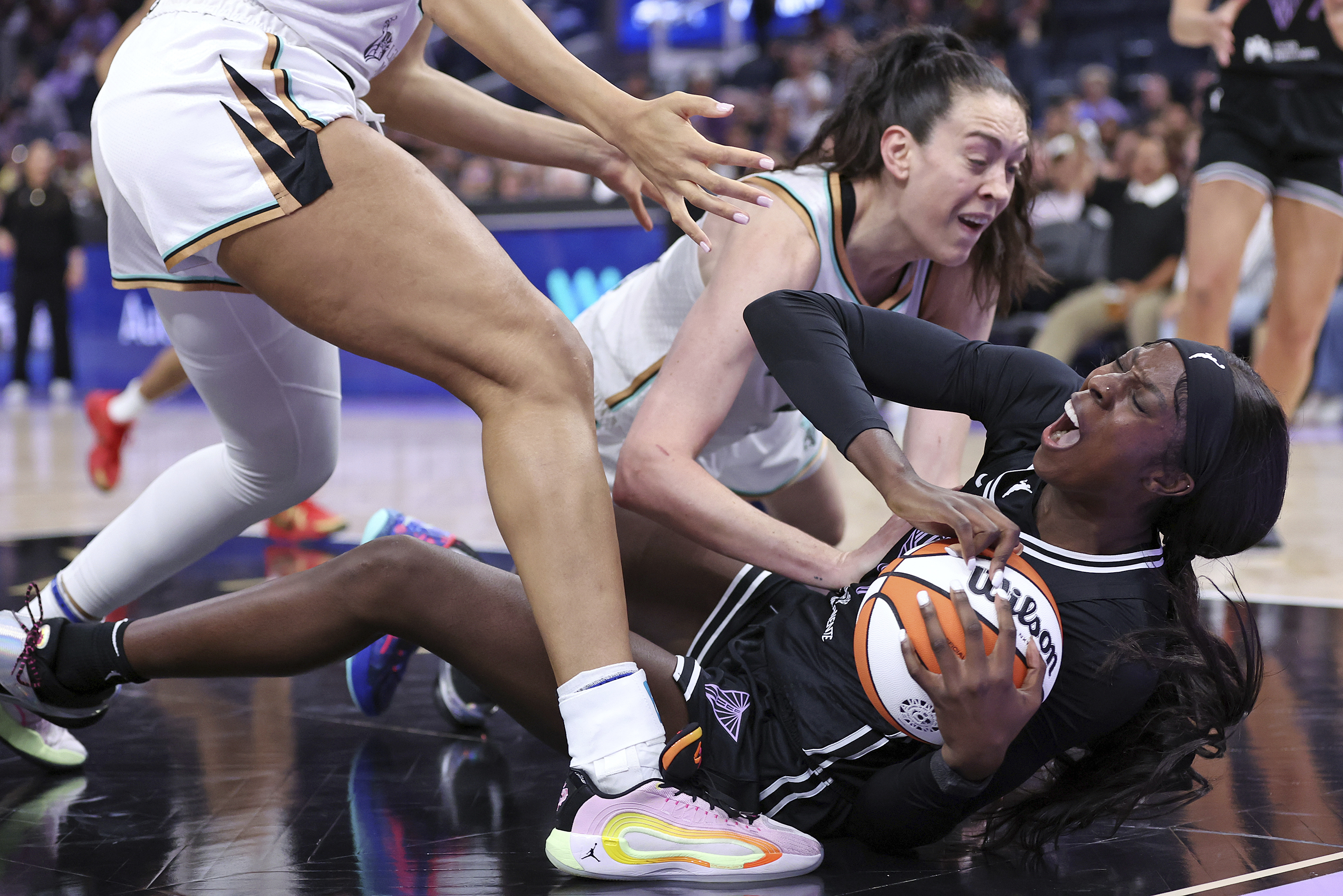Golden State Valkyries' Laeticia Amihere, bottom, is fouled by New York Liberty's Breanna Stewart during an WNBA basketball game in San Francisco on Wednesday, June 25, 2025. 