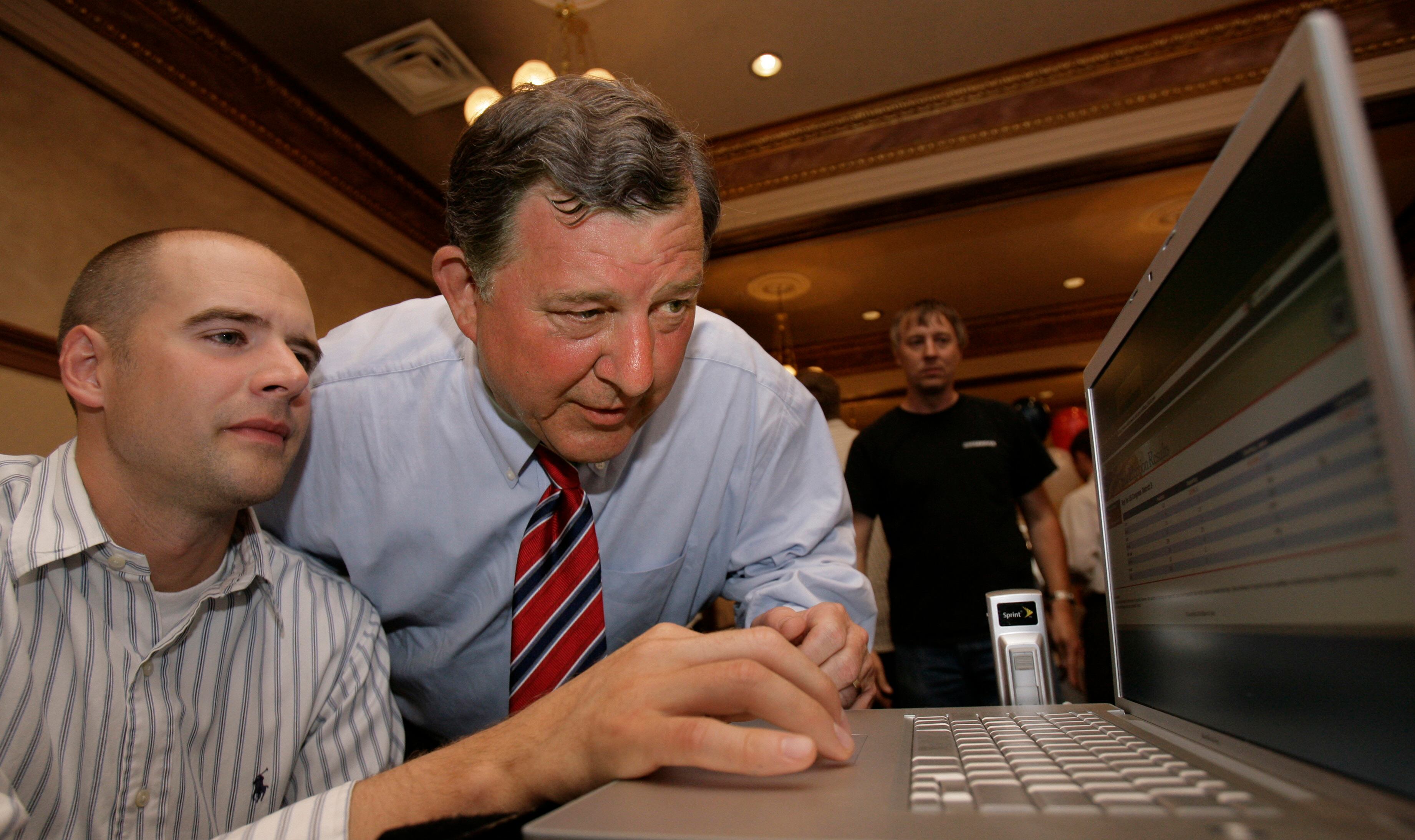 Rep. Chris Cannon looks at the returns with staff member Corey Norman on June 24, 2008, in Provo, Utah. Norman first worked for Cannon as an unpaid intern in 1999.