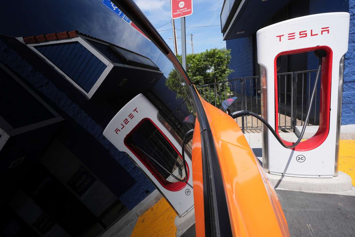 An electric vehicle charges at a station May 22 in Long Beach, Calif. Sen. John Curtis included language in President Donald Trump's tax bill that will delay expiration of green energy credits to give companies time to adjust.