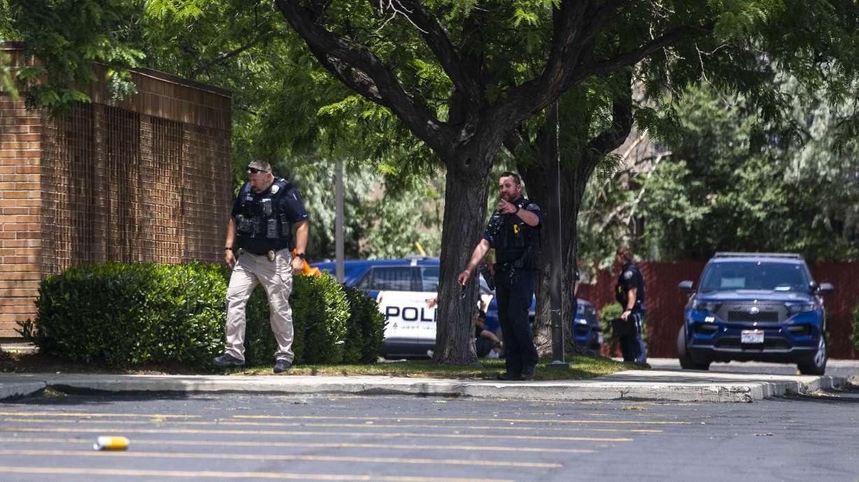West Valley police officers look for evidence after a shooting outside of a church meetinghouse in West Valley City on Wednesday.