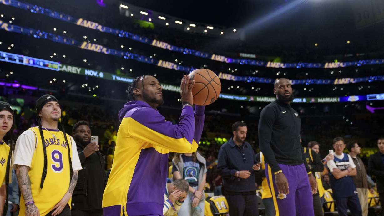 FILE - Los Angeles Lakers guard Bronny James, left, and forward LeBron James warm up before an NBA basketball game against the Minnesota Timberwolves, Oct. 22, 2024, in Los Angeles.