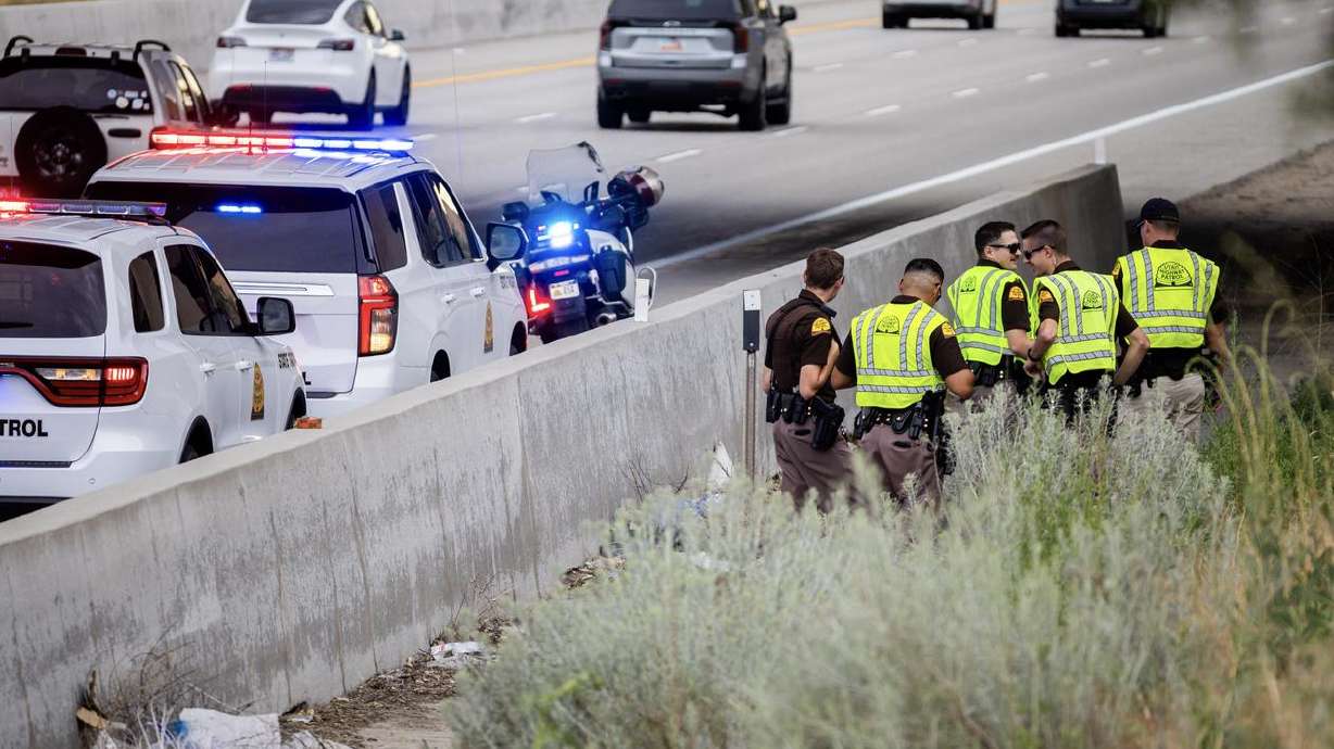 Troopers work at a crash scene Thursday evening after a motorcyclist hit the wall of an I-215 on-ramp in Midvale and was killed.