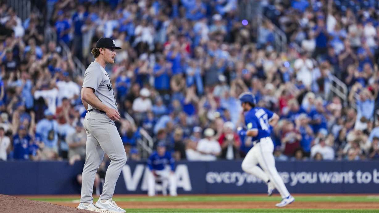 New York Yankees pitcher Clayton Beeter, left, reacts after giving up a home run to Toronto Blue Jays' Addison Barger (47) during fifth-inning baseball game action in Toronto, Thursday, July 3, 2025.