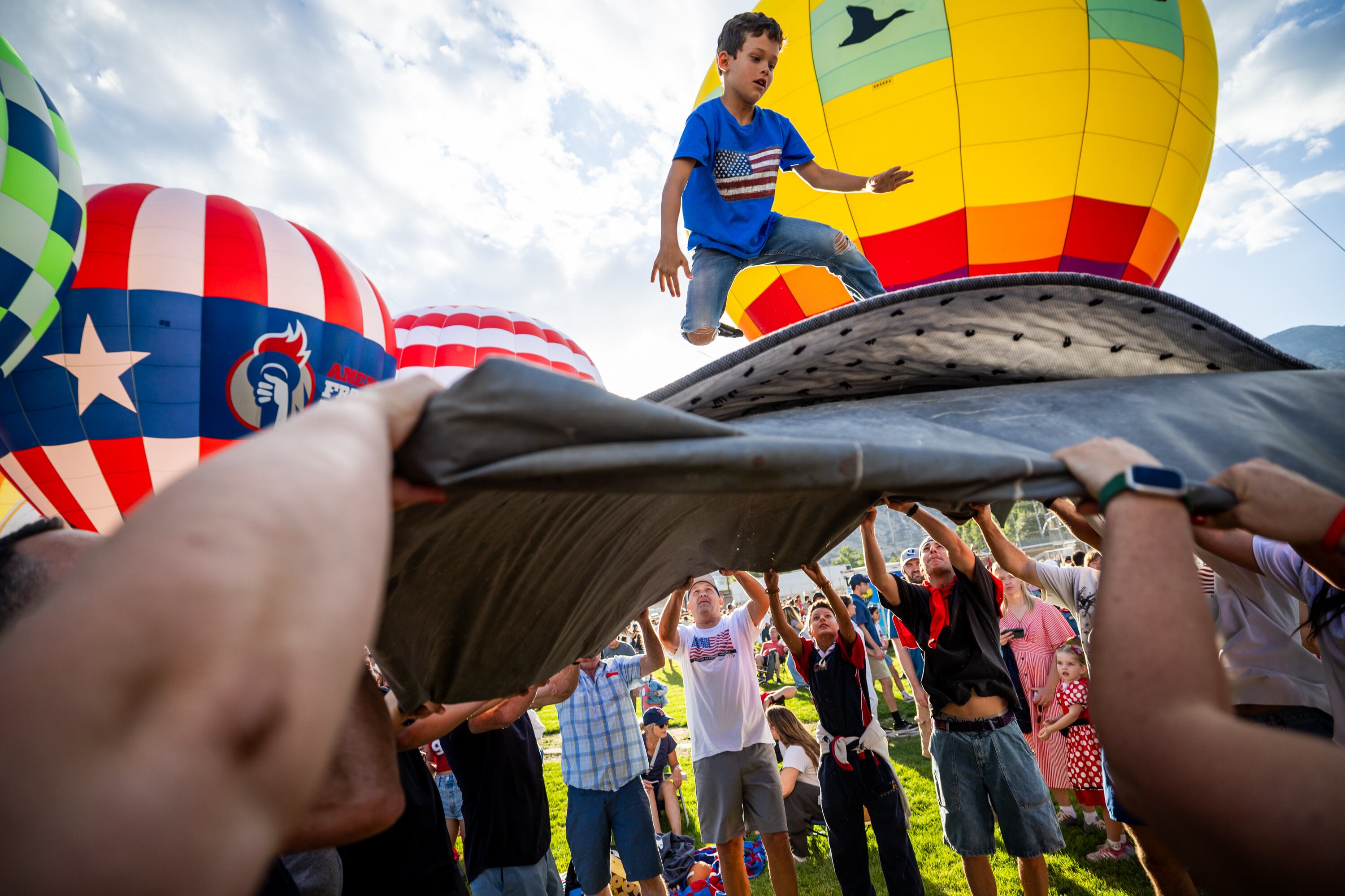 McKay Brink, 7, is lifted into the air at the Freedom Festival Balloon Fest in Provo on Friday.
