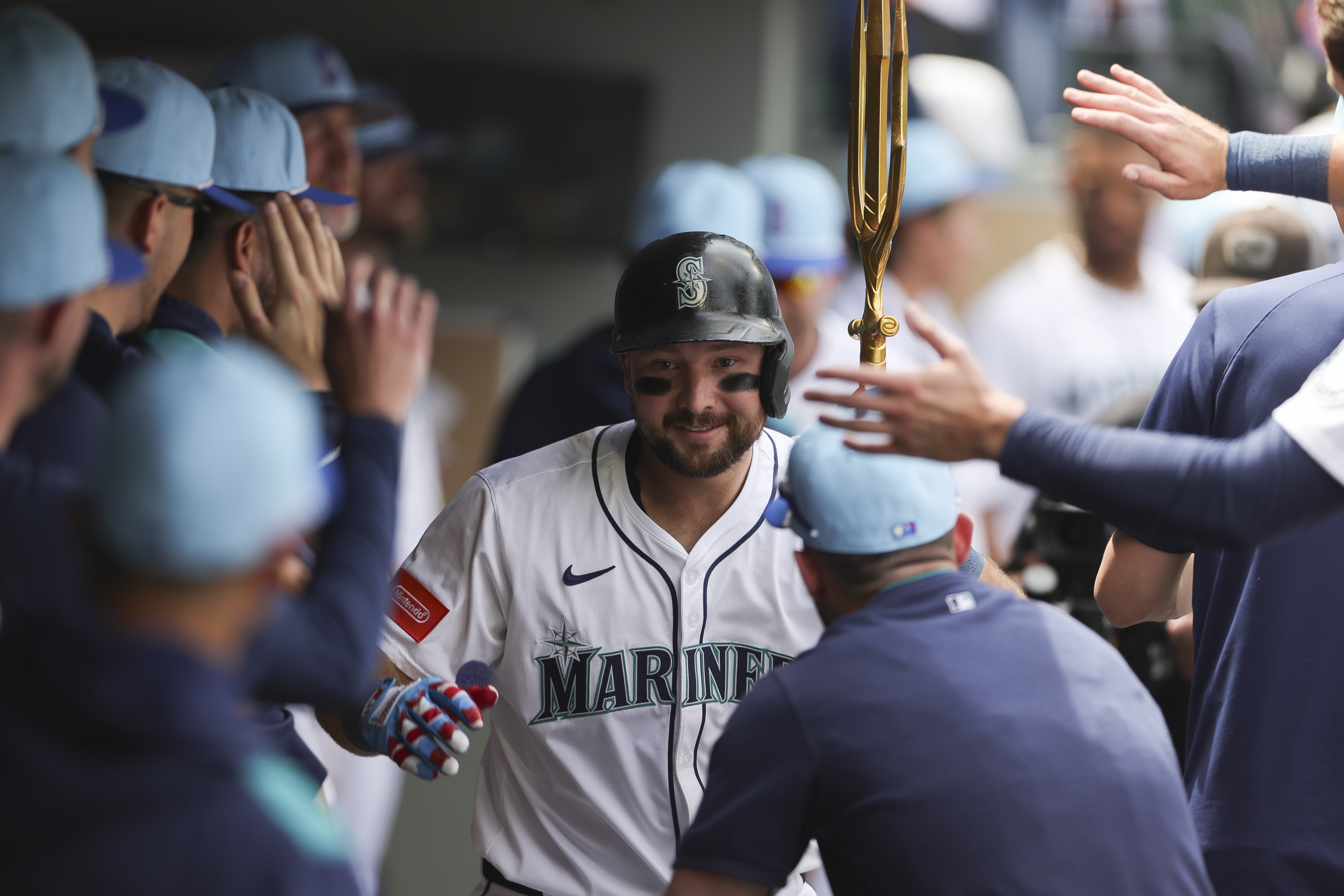Seattle Mariners designated hitter Cal Raleigh celebrates in the dugout after hitting a solo home run during the sixth inning of a baseball game against the Pittsburgh Pirates, Friday, July 4, 2025, in Seattle. 